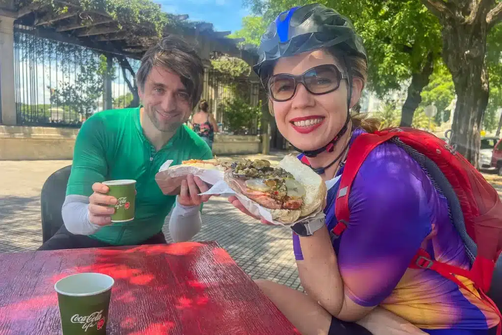 comiendo un choripan en una parada de un paseo en bicicleta