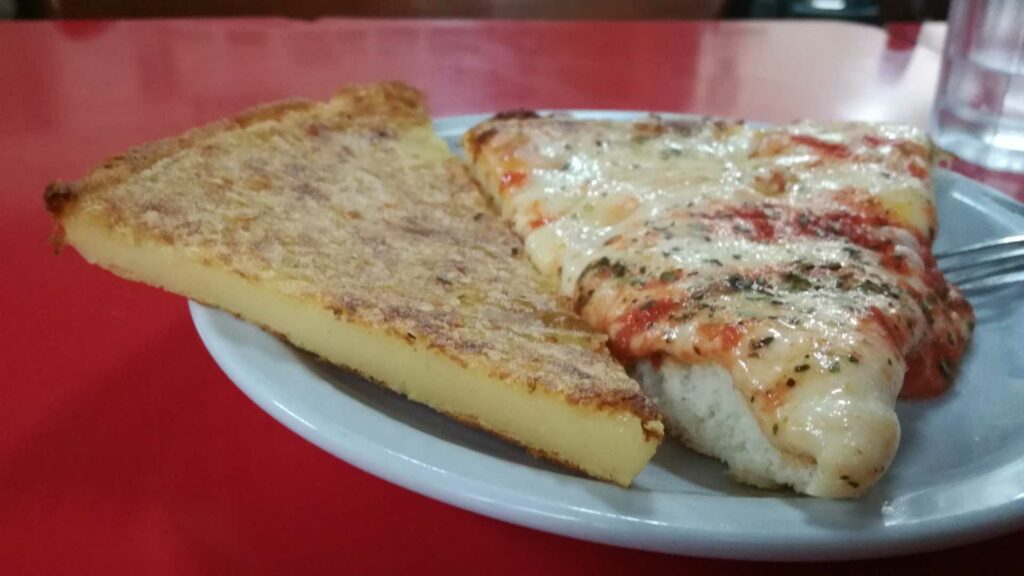 Tipica porción de pizza con faina en buenos aires