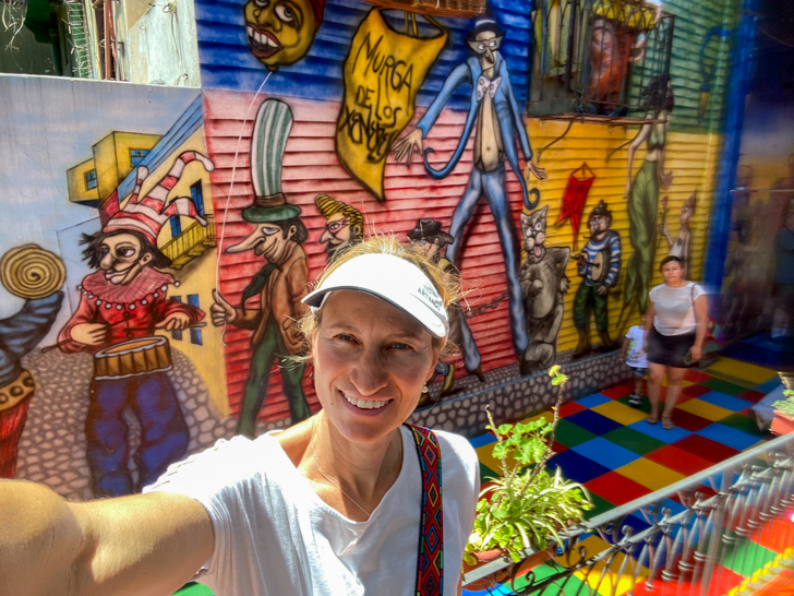 a girl taking a picture in caminito area that is very colorful