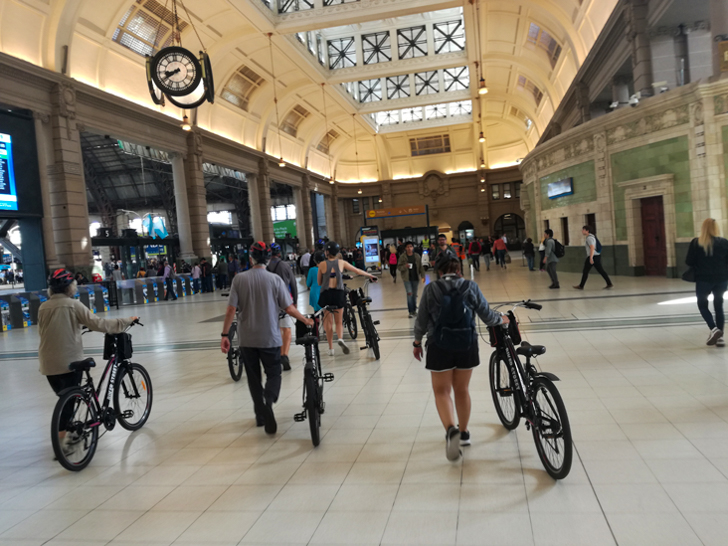 Gente caminando con bicicletas en la estación de retiro.